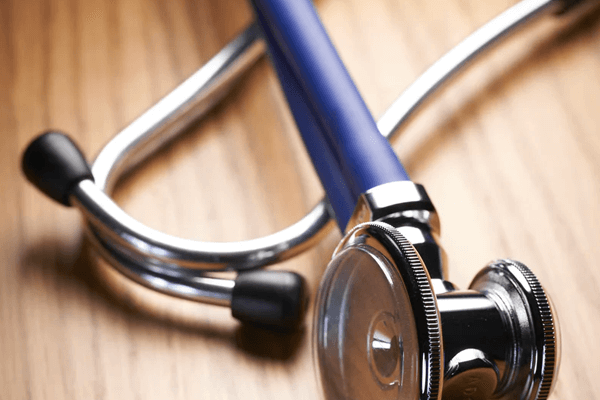 Blue stethoscope on a wooden surface.