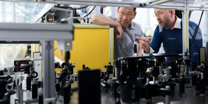 Two scientists discussing equipment in laboratory.
